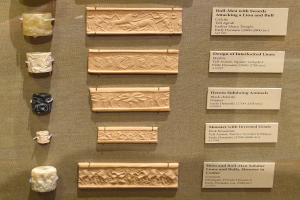 Vitrine voller verschiedener altertümlicher Artefakte, darunter Reliefs und Inschriften auf Tafeln, ordentlich und sauber angeordnet.