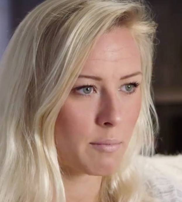 Blonde Frau mit blauen Augen in Not, Hintergrund unscharf, wahrscheinlich aufgrund der Zwangspause.