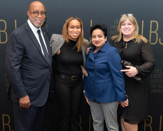 Vier Personen auf einem roten Teppich bei den 'Liberty Justice for All Awards', die für ein Foto posieren