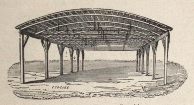 Ein hölzernes Unterschlupf mit einem geneigten Dach, das von Säulen gestützt wird, mit einer schuppenähnlichen Struktur und Text unten.