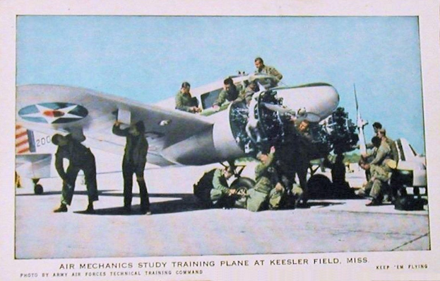 Gruppe von Menschen um ein Trainingsflugzeug auf einer Landebahn mit einem klaren blauen Himmel, Text unten lautet "Luftmechanikerstudium Trainingsflugzeug auf Keesler Field, Miss."