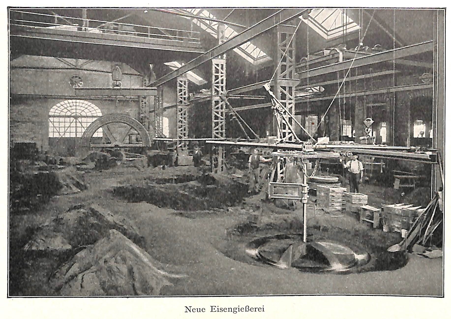 Schwarzes und weißes Foto einer Fabrik mit Arbeitern, die Maschinen bedienen, umgeben von Metallstangen und -pfählen, beschriftet mit 'Neue Eisenglebeerei, die erste Fabrik in Deutschland' unten.