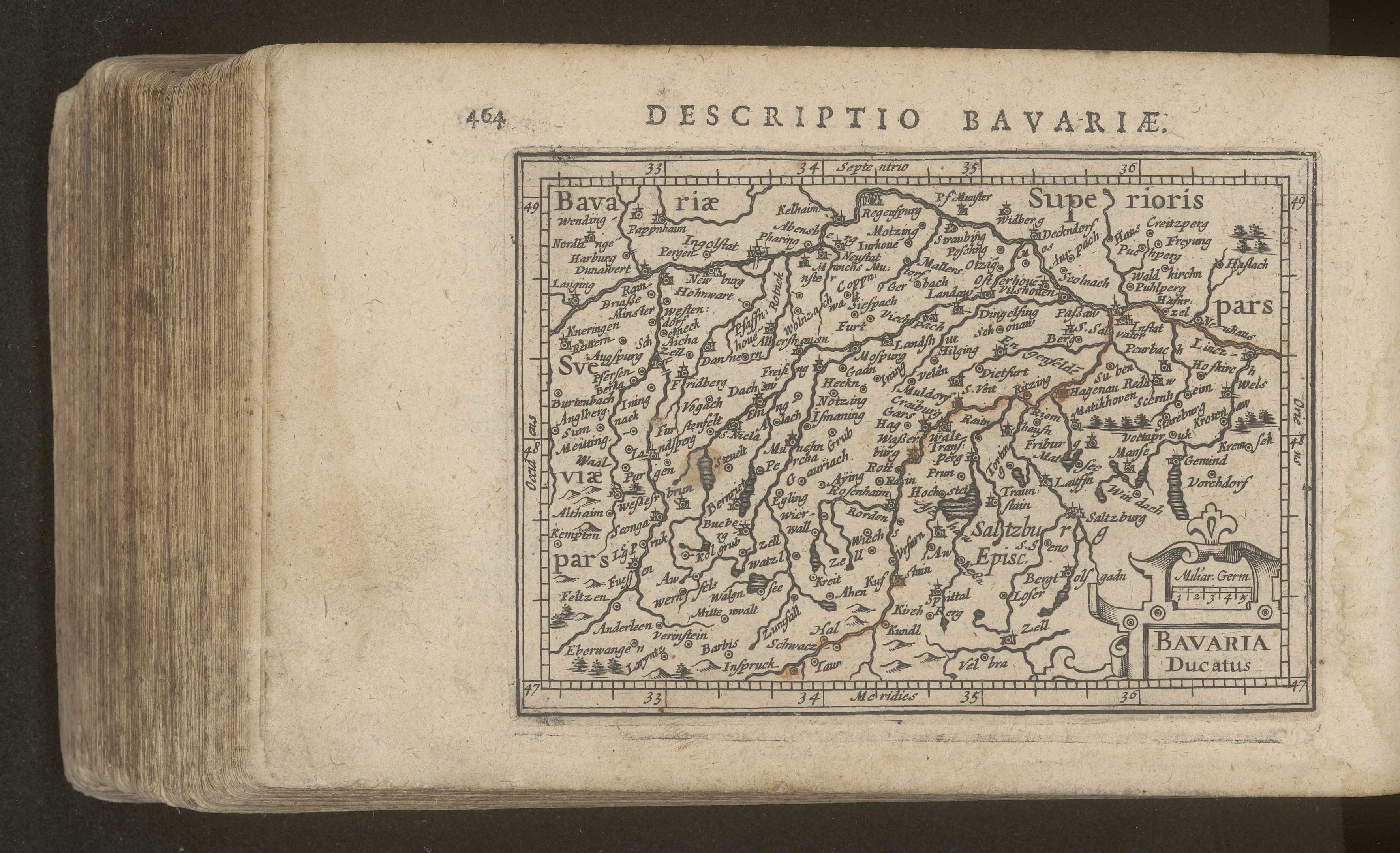 Altes Buch mit einer detaillierten Karte von Bayern auf dem Cover vor einem schwarzen Hintergrund.