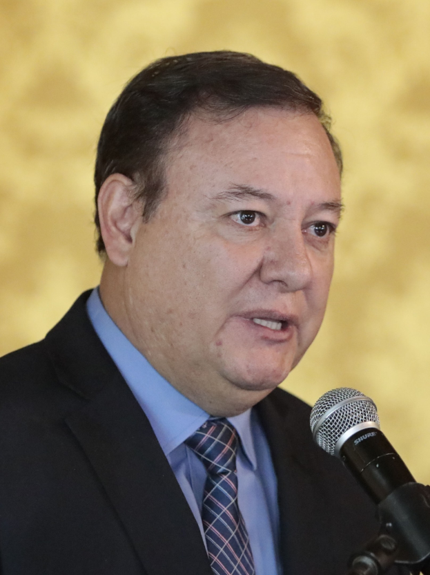 Ein Mann im Anzug und mit Krawatte, der in ein Mikrofon spricht, identifiziert als Generalstaatsanwalt.