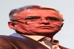 Ein Mann im Blazer, Krawatte und Brille vor einem weißen Hintergrund, identifiziert als CEO der Bank of England.