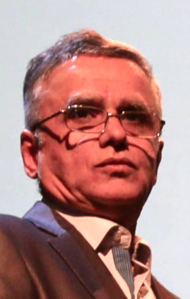 Ein Mann im Blazer, Krawatte und Brille vor einem weißen Hintergrund, identifiziert als CEO der Bank of England.