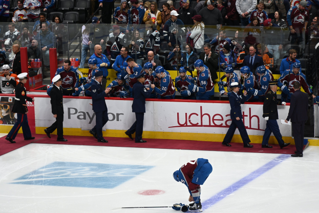 Hockeyspieler auf dem Eis von Fans und Teammitgliedern umgeben während eines Spiels von Colorado Avalanche gegen San Jose Sharks am 24. März 2015.
