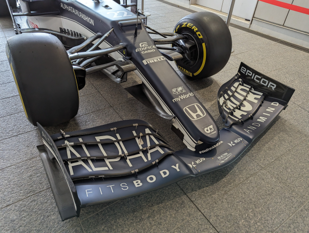 Ein schwarzer und weißer McLaren MP4-31 Formel-1-Wagen, der im McLaren Museum ausgestellt ist und einen großen Heckflügel und eine aerodynamische Gestaltung aufweist.