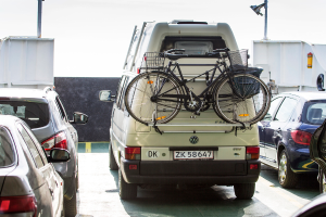 Verschiedene Fahrzeuge, einschließlich Autos und Fahrräder in verschiedenen Farben, sind in der Mitte des Bildes positioniert.
