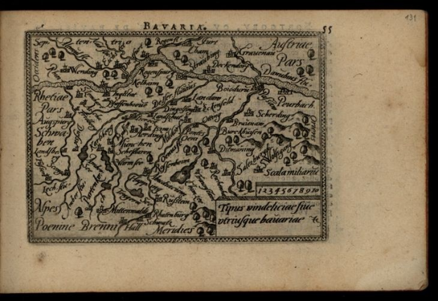 Ein detailliertes altes Buch mit einer Karte von Bayern, das Städte und Ortschaften zeigt, auf einem schwarzen Hintergrund.