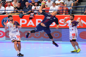 Gruppe von Männern, die Handball auf einem Court spielen, mit einem Ball im Spiel, Zuschauern im Hintergrund und einem Banner für das Futsal-Weltmeisterschaftsspiel 2015 zwischen Paris Saint-Germain und Olympique Lyon.