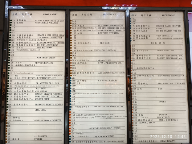 Speisekarte mit chinesischer Schrift vor einem Gebäude, die wahrscheinlich Speisen aus einem chinesischen Restaurant auflistet.